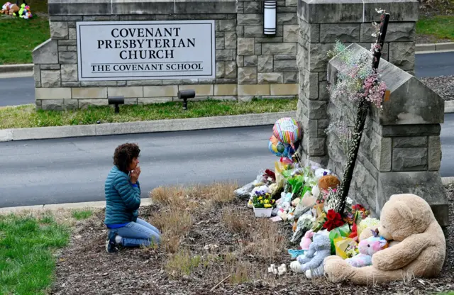 Robin Wolfeden prays in front of a makeshift memorial by the entrance of the Covenant School the day after a mass shooting in Nashville, Tennessee, US March 28, 2023