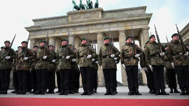 Members of the military stand in line during a rehearsal in front of Brandenburg Gate in Berlin