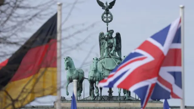 The German and British flags fly near the Quadriga Statue at the Brandenburg Gate