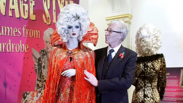 Paul O'Grady seen in 2011 next to a mannequin wearing one of Lily Savage's costumes