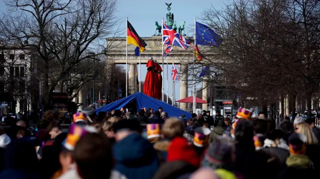 People queue in front of the Brandenburg gate in Berlin, ahead of the arrival of King Charles