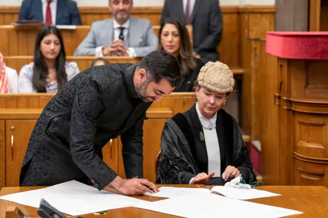 Humza signs the parchements