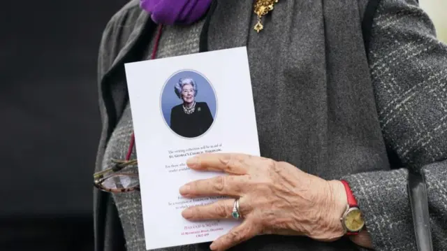 Mourner holds order of service at Betty Boothroyd's funeral