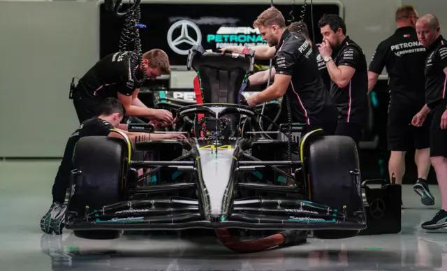 Mercedes mechanics work on Lewis Hamilton's car