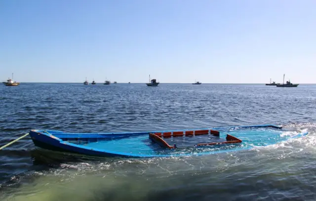 A picture taken on October 13, 2020, shows a boat, which was carrying 29 people and sank off the Tunisian coast, being towed near the Tunisian coastal town of Amra.