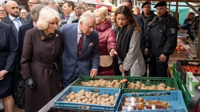 Camilla and Charles look at stalls in street market