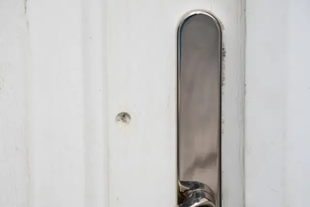 A bullet hole in a white door