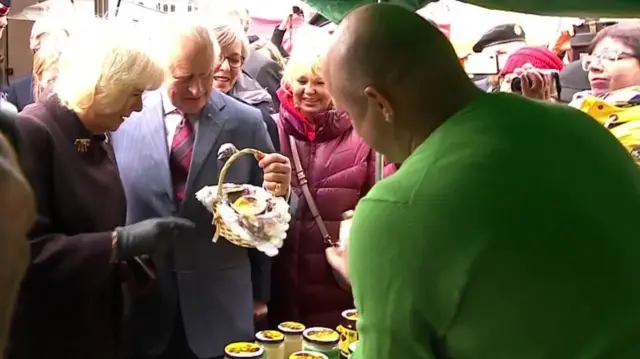 The pair receive a gift of a basket of honey at the market