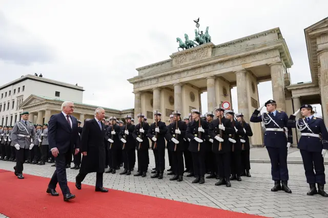 King Charles and German President Frank-Walter Steinmeier inspect troops in front of the Brandenburg Gate in Berlin