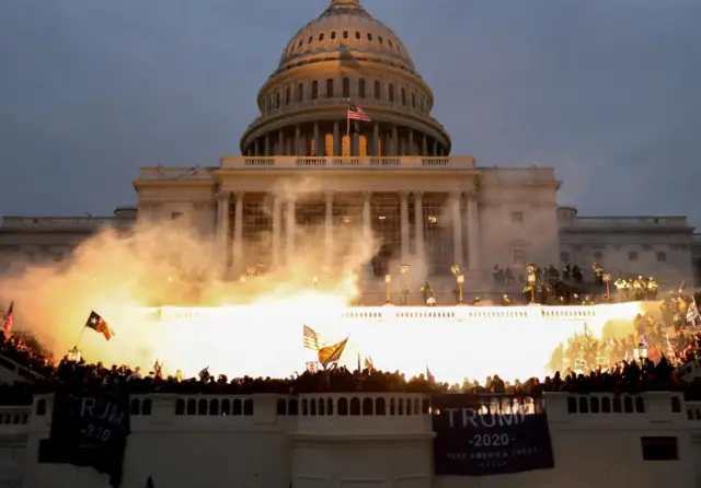 An explosion caused by a police munition is seen while supporters of Trump riot in front of the Capitol Building in Washington on 6 January 2021.