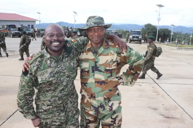 Caption: M23 military spokesperson (right) seen welcoming Ugandan troops at the border of Bunagana on Thursday