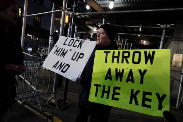 Protesters holding placards which read: "Lock 'him' up and throw away the key"