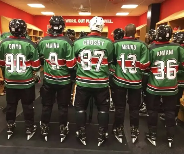 Kenya Ice Lions Hockey Team standing in a row showing their names on their shirts.