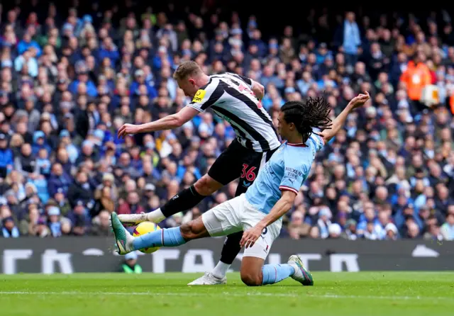 Manchester City defender blocks the shot from Newcastle midfielder Sean Longstaff