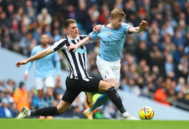 Manchester City's Kevin de Bruyne tussles with Newcastle defender Sven Botman