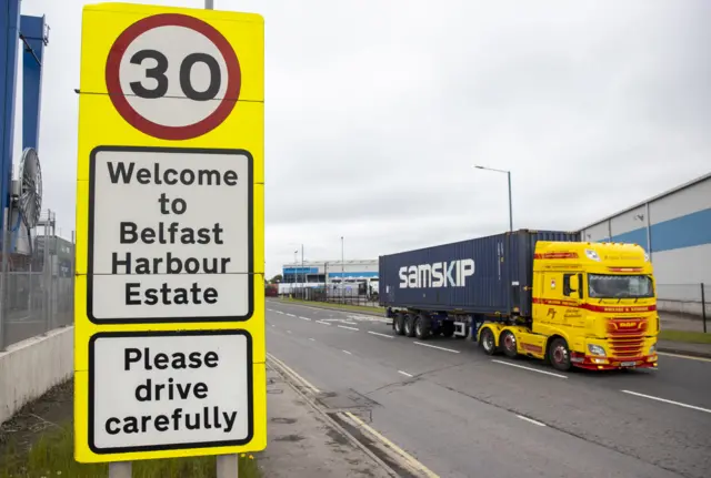 A lorry passes a sign for Belfast Harbour