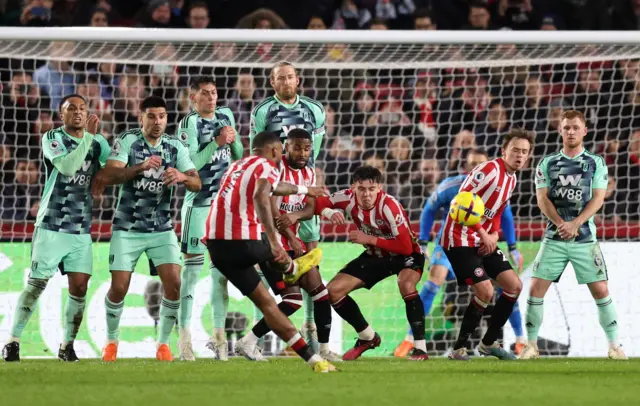 Ivan Toney takes a free-kick that hits the crossbar.