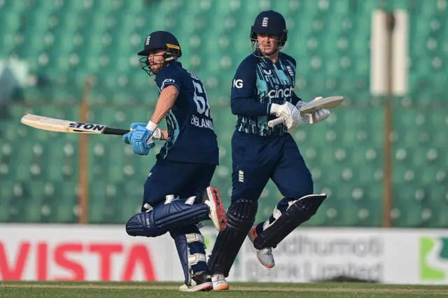 England's Jason Roy (R) with teammate Phil Salt run between the wickets during the third one-day international (ODI) cricket match between Bangladesh and England at the Zahur Ahmed Chowdhury Stadium in Chittagong