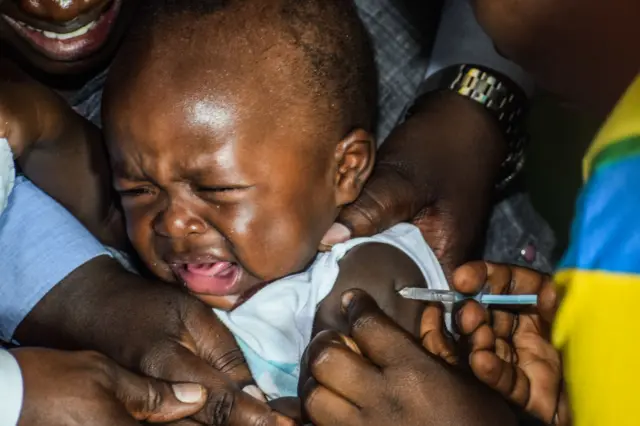 A crying baby is given a Malaria vaccine in Kenya.