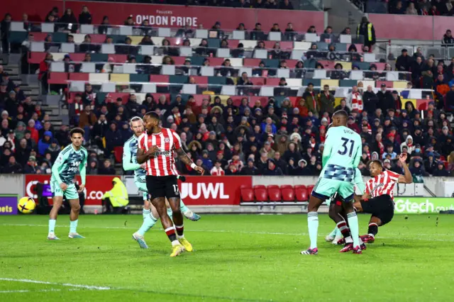 Ethan Pinnock's shot deflects off Tim Ream as it heads towards goal. Ivan Toney looks on.