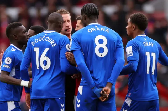 Everton players crowd the referee