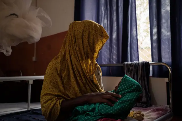 A mother cradles her child suffering from severe malnutrition in the ICU of Bay Regional Hospital in Baidoa, Somalia on November 9, 2022.