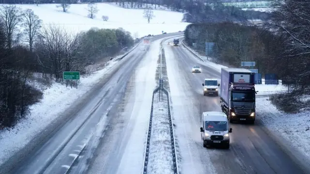 Cars travel along a snow covered A1 motorway at Alnwick in Northumberland