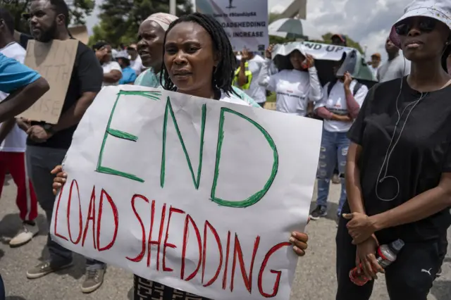 People, holding banners, stage a protest against energy crisis