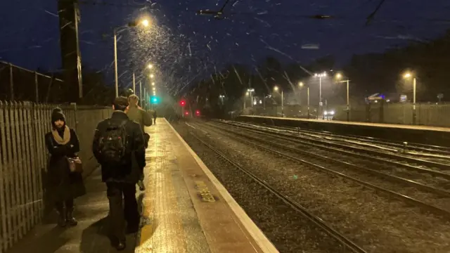 Commuters brave the cold during snow fall at Hitchin train station in Hertfordshire this morning