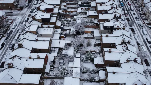 An aerial view of houses and gardens covered in snow in London in December 2022