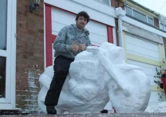 Andy Rawbone sitting on a motorbike sculpture made out of snow