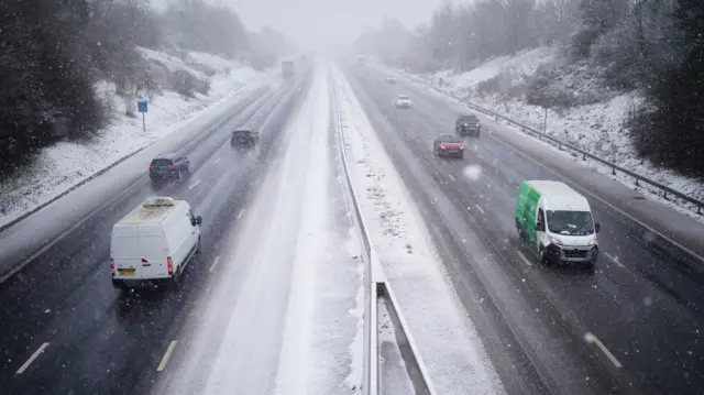 Traffic driving along a snowy motorway