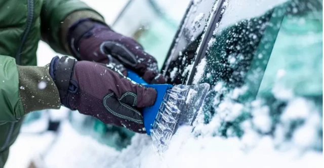 Person de-icing a car