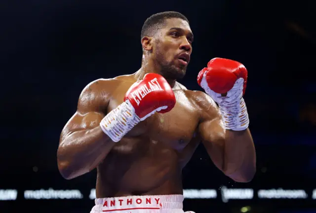 Anthony Joshua holds up his hands in the ring