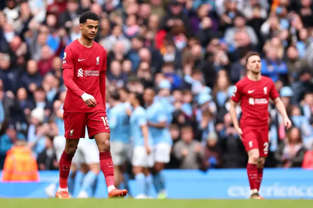 LiMan City players celebrate in the background as Liverpool stand dejected.