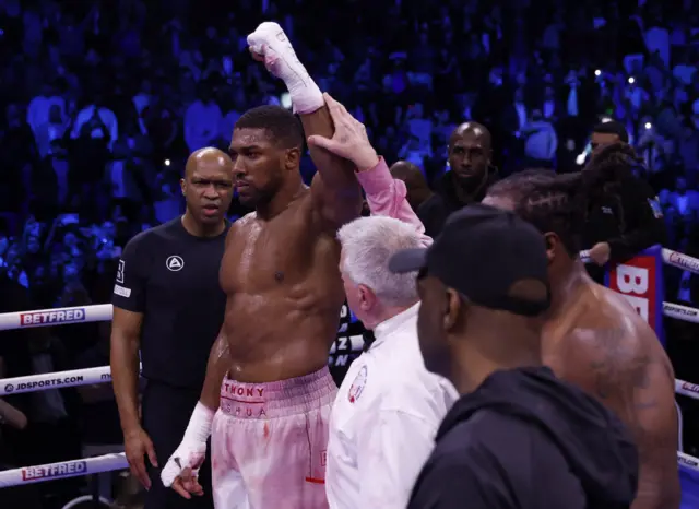 Anthony Joshua has his hand raised by the referee