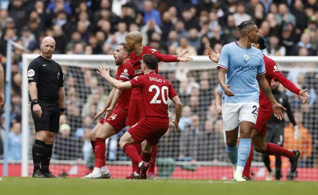 Liverpool players remonstrate with referee Simon Hooper.