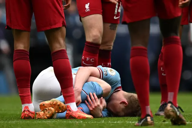 Man City midfielder Kevin de Bruyne lies injured on the floor.