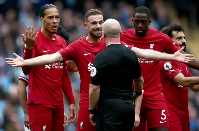 Liverpool players surround the referee.