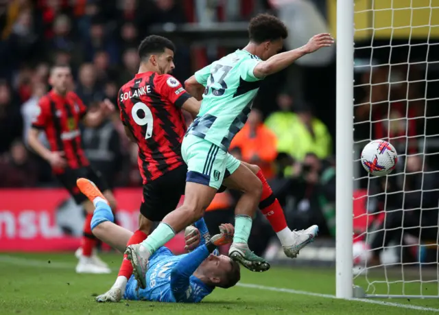 Dominic Solanke of AFC Bournemouth kicks the ball over the goal keeper who is on the floor