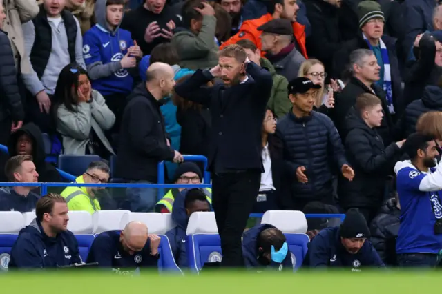 Graham Potter, Manager of Chelsea, has his hands behind his head