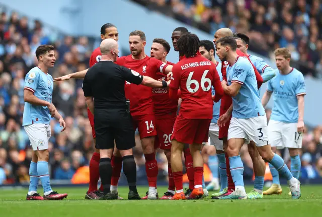 Liverpool players surround referee Simon Hooper.