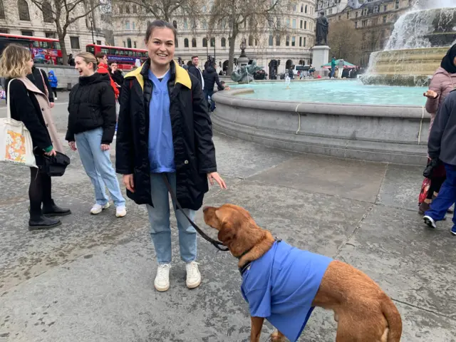 Junior doctor with her dog wearing scrubs