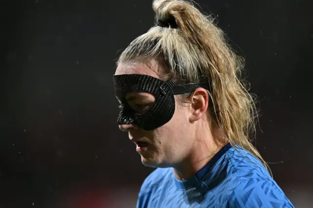 Lauren Hemp struggles with her protective face mask.