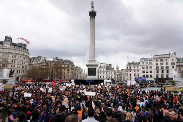 Hundreds of people gather around Nelson's column in Trafalgar square