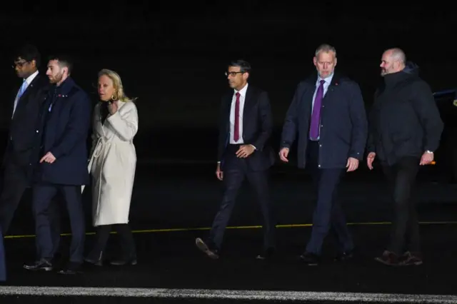 Sunak walking off from Biden's flight arrival in Belfast, Northern Ireland