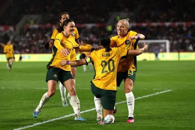 Australia celebrate their opening goal.