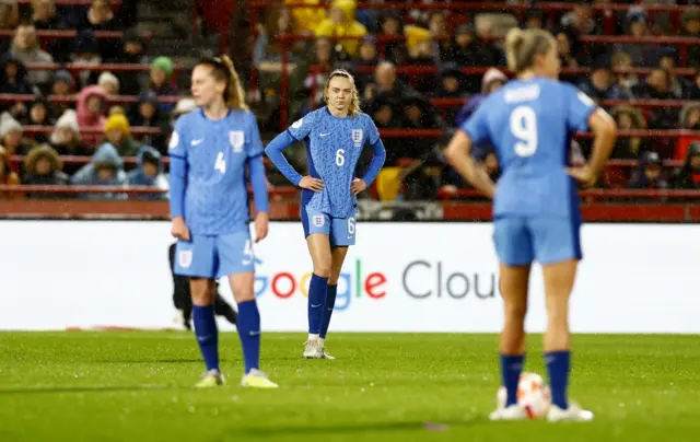 England commiserate after conceding the opening goal.