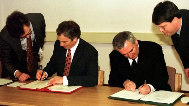 Tony Blair Bertie Ahern signing documents in 1998