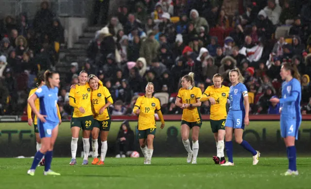 England watch on as Australia celebrate scoring.